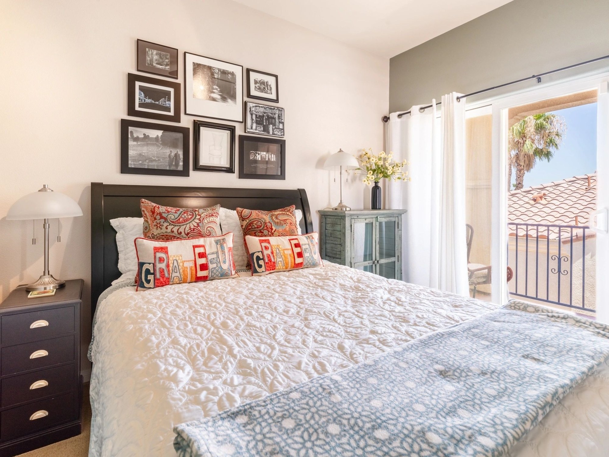 Bright bedroom with decorative pillows and framed pictures
