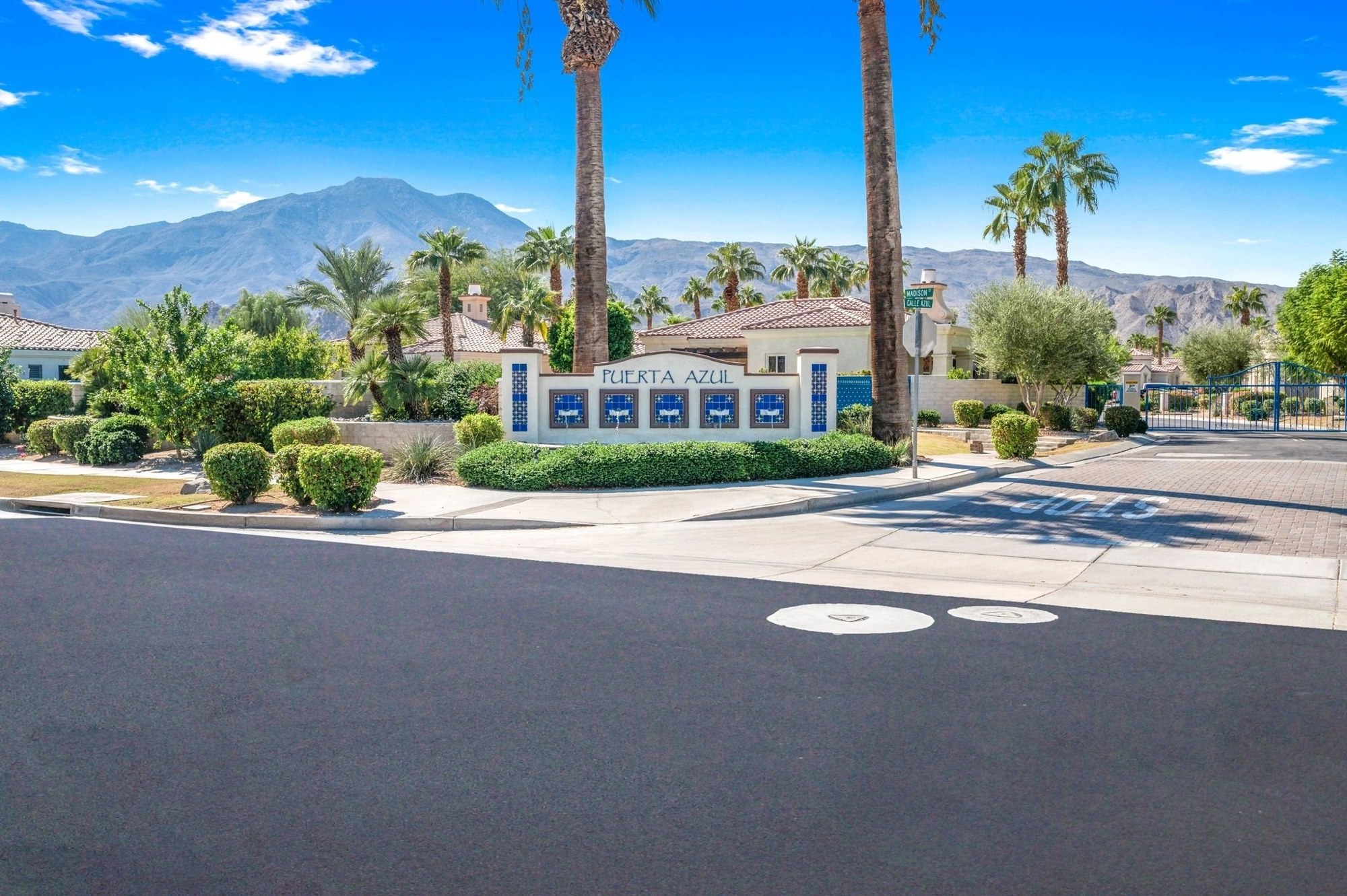 Puerta Azul gated community entrance with palm trees and La Quinta mountains